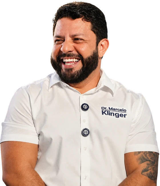 Dr. Marcelo Klinger sorrindo, com camisa branca da campanha